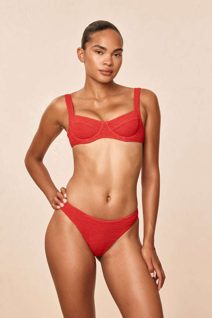 Front view of Seychelles bottom in chili pepper crinkle showing modest coverage and textured fabric on model