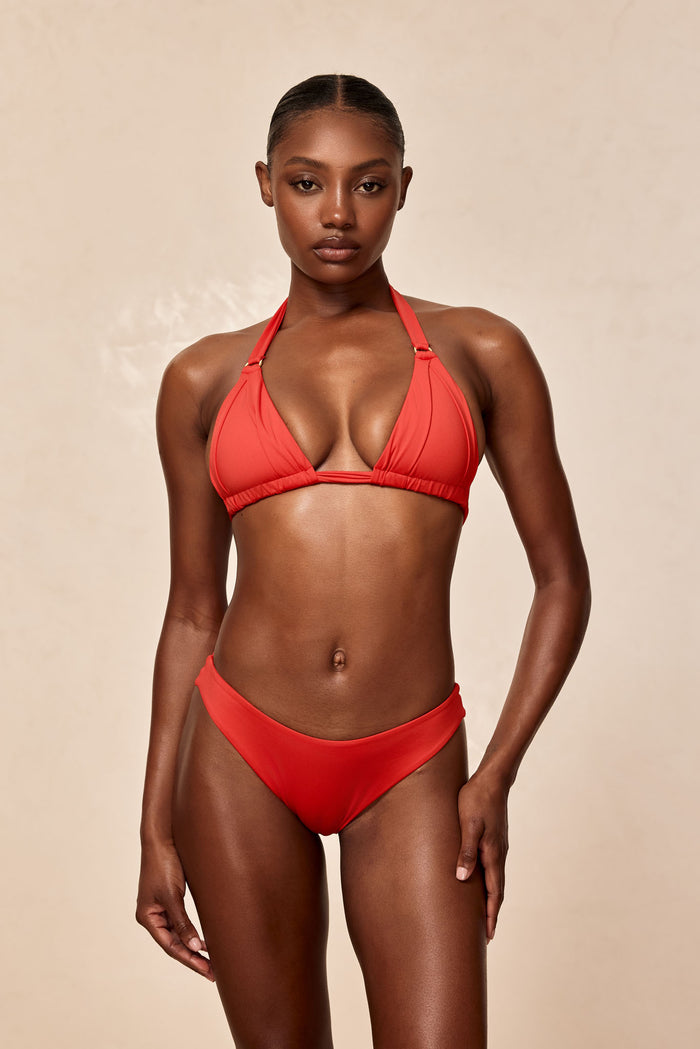 Front view of Seychelles bottom in Chili Pepper on model showcasing modest coverage with neutral beige background