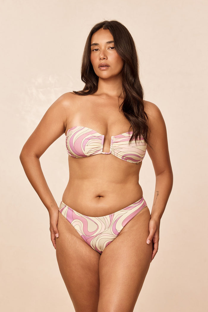 Front view of Seychelles Bottom in Costa Rei Pink, mid-rise moderate coverage, swirl print, worn by model on beige background