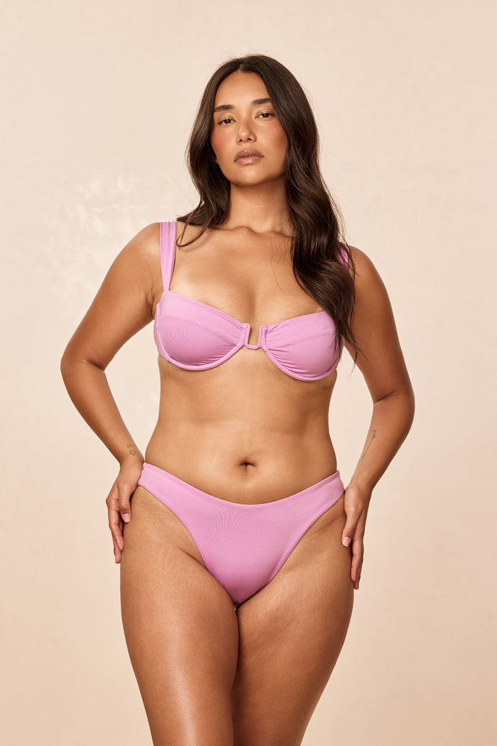 Front view of Seychelles Bottom in Moonlight on model showcasing mid-rise, moderate coverage with neutral beige studio background