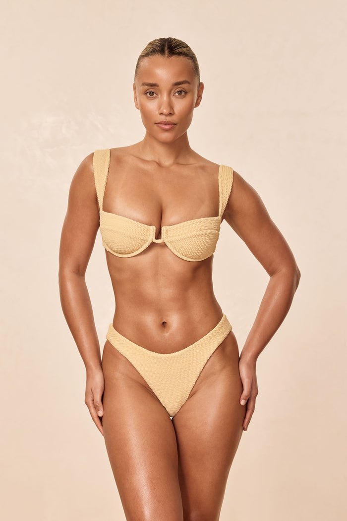 Front view of Seychelles Bottom in Raffia Crinkle, high cut textured fabric on model against a beige background