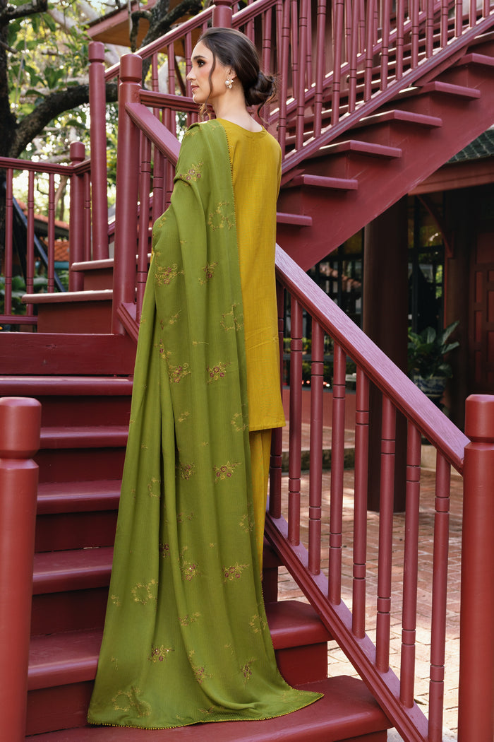 Woman in a green saree standing on a red staircase