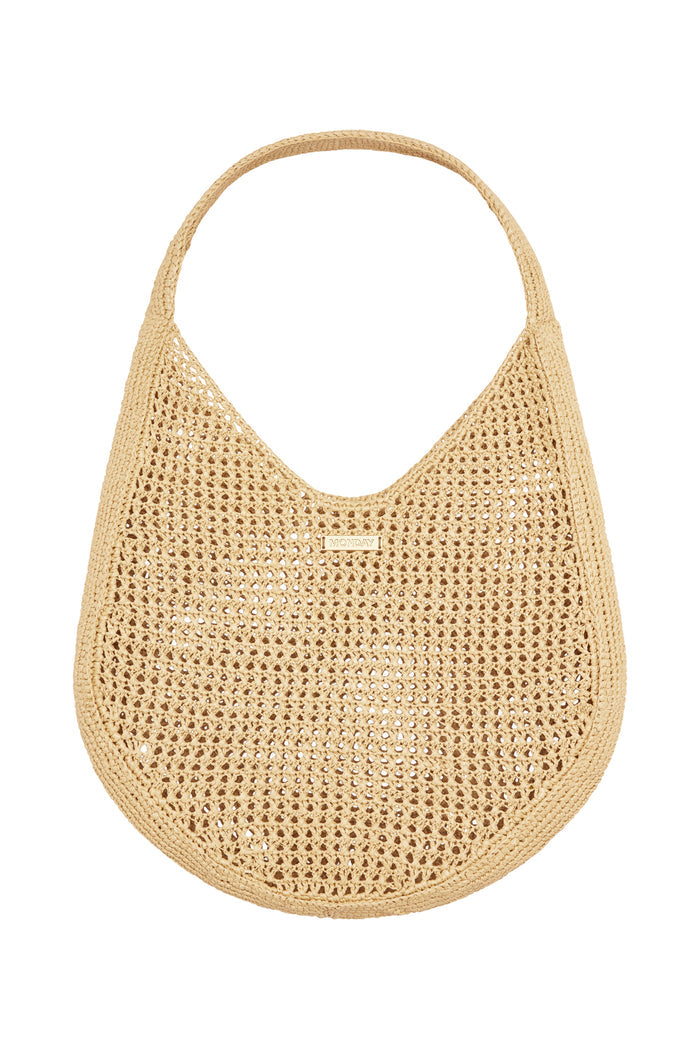 Front view of Shell Beach Bag in Natural showcasing open woven texture, wide shoulder strap and MONDAY logo tag on white background