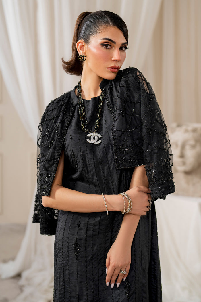 Macro shot of naqshi siara shirt front showcasing delicate sequin embroidery on black raw silk with geometric motifs.