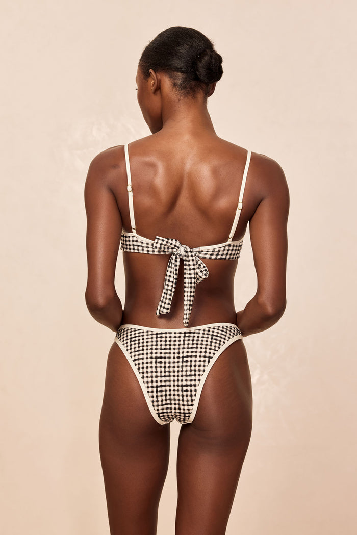 Back view of Somerset Bottom in Black Gingham showing cheeky, high-cut leg and cream contrast binding on beige background