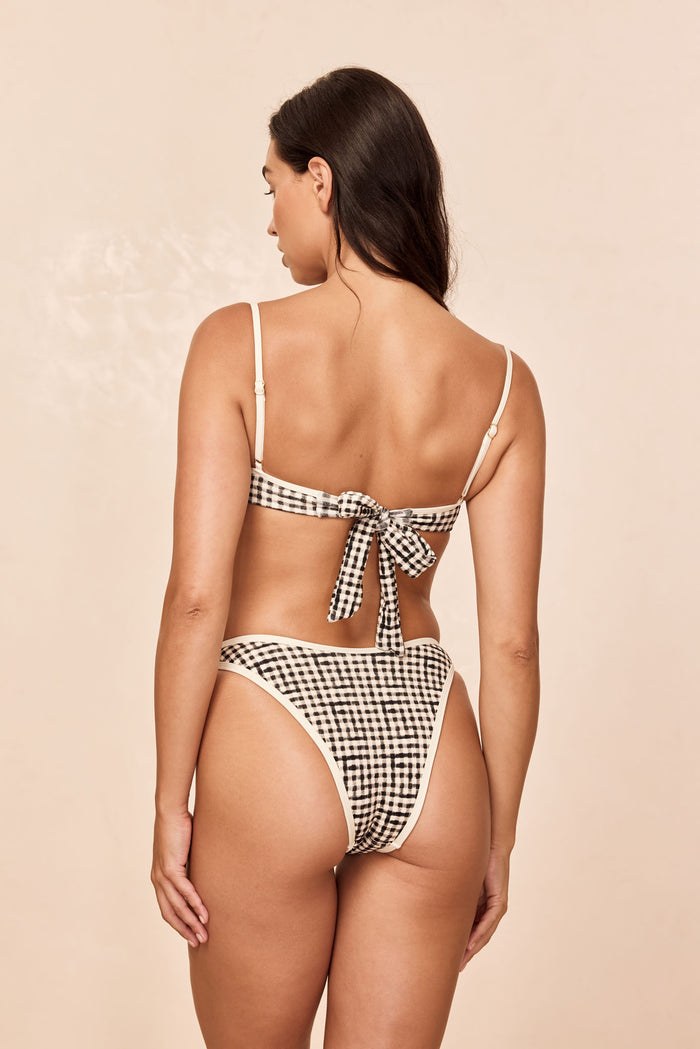Back view of Somerset Bottom in Black Gingham showcasing high-cut cheeky coverage and cream binding on a beige background