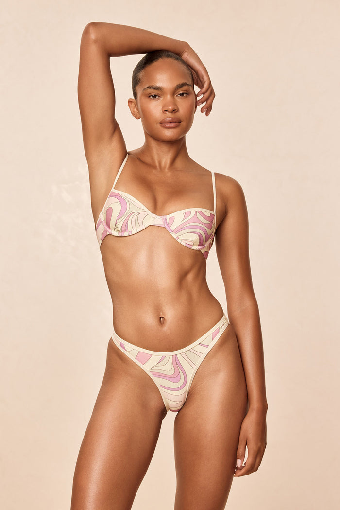 Front of Somerset bottom in Costa Rei Pink/Ivory, high-cut leg, mid-rise waist and binding detail on model, beige background