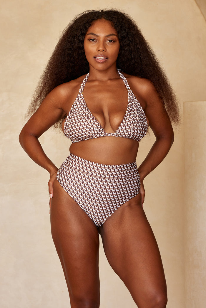 Three-quarter front of Sorrento Bottom in Husk Geo print showing high-rise waist with matching halter top on beige background