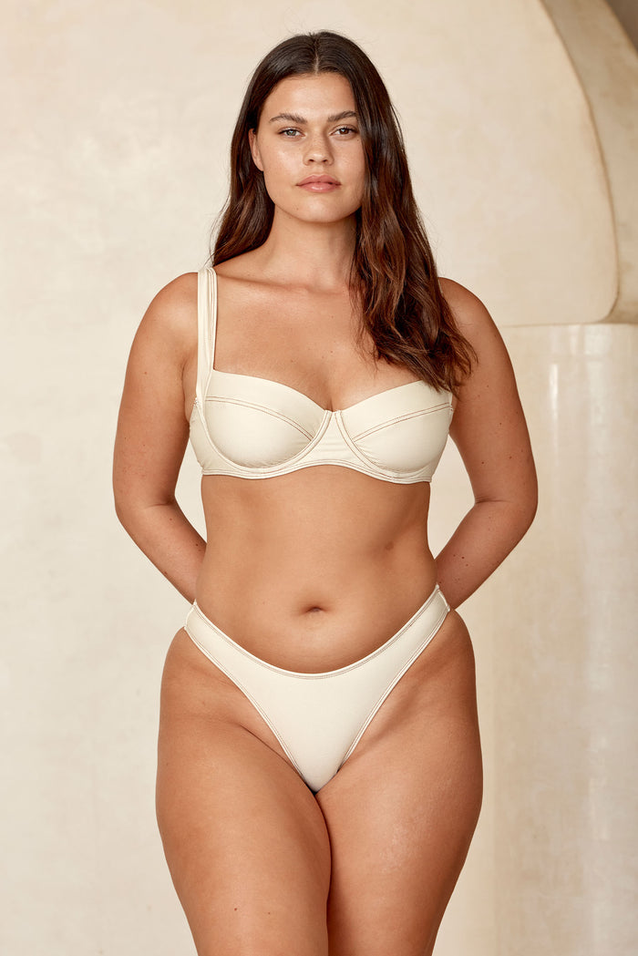 Front view of Byron Bottom in Champagne Denim showcasing mid-rise fit, high-cut leg and textured fabric against a neutral backdrop