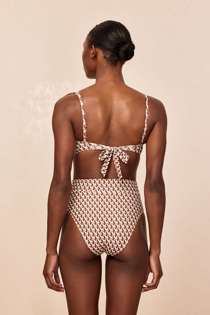 Rear view of Sorrento Top in Husk Geo brown-and-cream print showing tie-back closure and adjustable straps on beige background