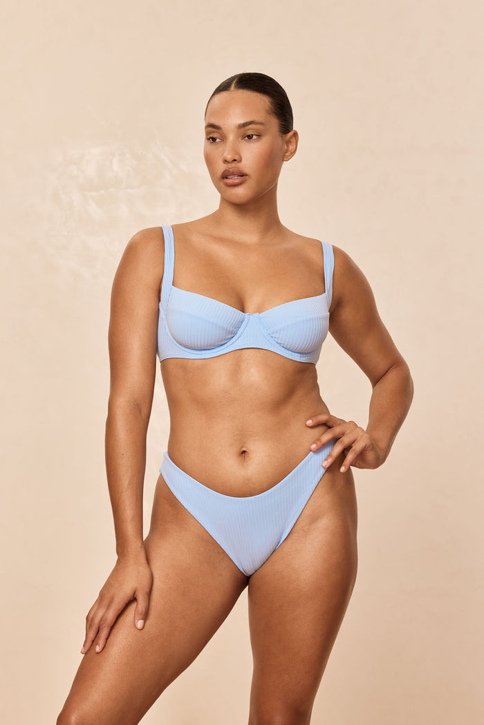 Front view of Sorrento Top in Sky Rib showing underwire cups and ribbed texture on model against beige background
