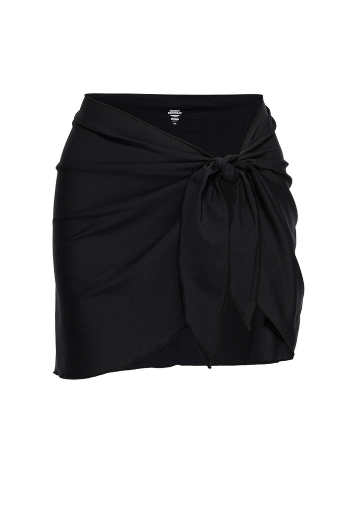 Close-up front of St. Barth’s Skirt in black showcasing adjustable side-tie wrap and mini length on white background