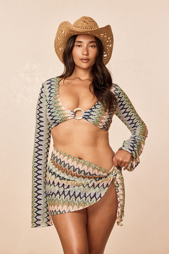 Front on model of St. Barth’s skirt Porto Cervo Multi showcasing wrap side tie and high slit against beige background