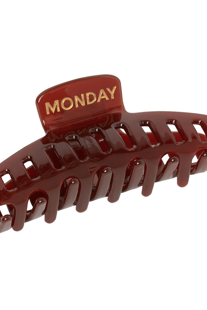 Glossy maroon hair claw clip with gold MONDAY label on top tab