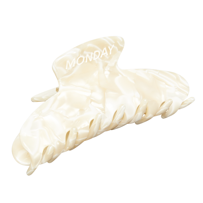 Pearlized cream hair claw clip with the word MONDAY printed on the top