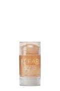 Front view of Kopari Sun Shield Sheer Stick SPF 40 showing golden shimmer in a clear plastic tube on white background