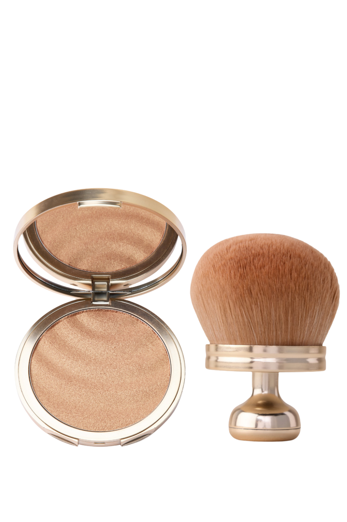Front view of Sun Veil Illuminating SPF 30 compact with shimmery powder and matching kabuki brush on white background