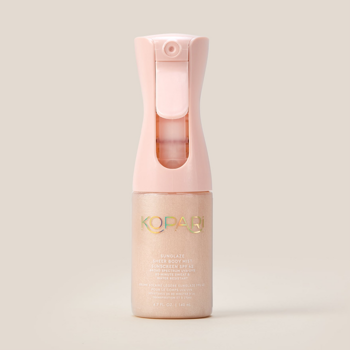 Front view of Sunglaze sheer body mist sunscreen SPF 42 bottle showing pink spray trigger and pearlescent golden shimmer on a beige background