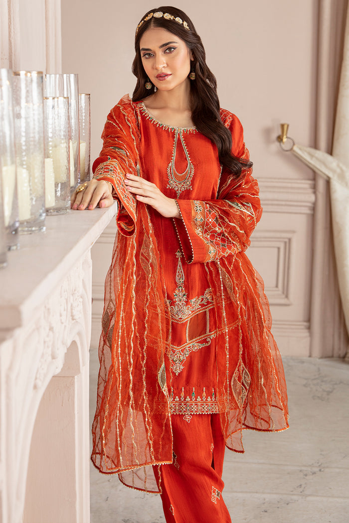 Side styling view of Syara orange ensemble featuring flowing net dupatta and embroidered sleeve borders, formal ready made eastern wear.