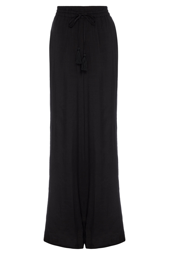 Front view of Tahiti Pant in black showcasing elastic drawstring waist with tassels, wide flared leg and small center slit on a white background