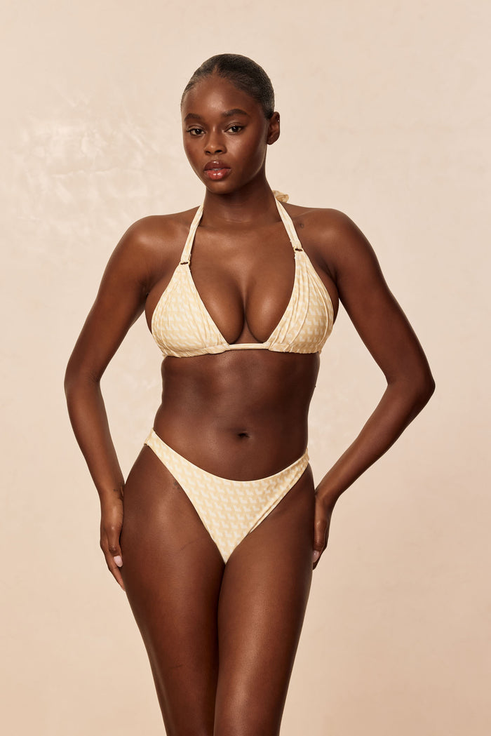 Front view of Tamarama Bottom in Ivory Geo on model showcasing cheeky mid-rise, high-leg cut with beige studio background