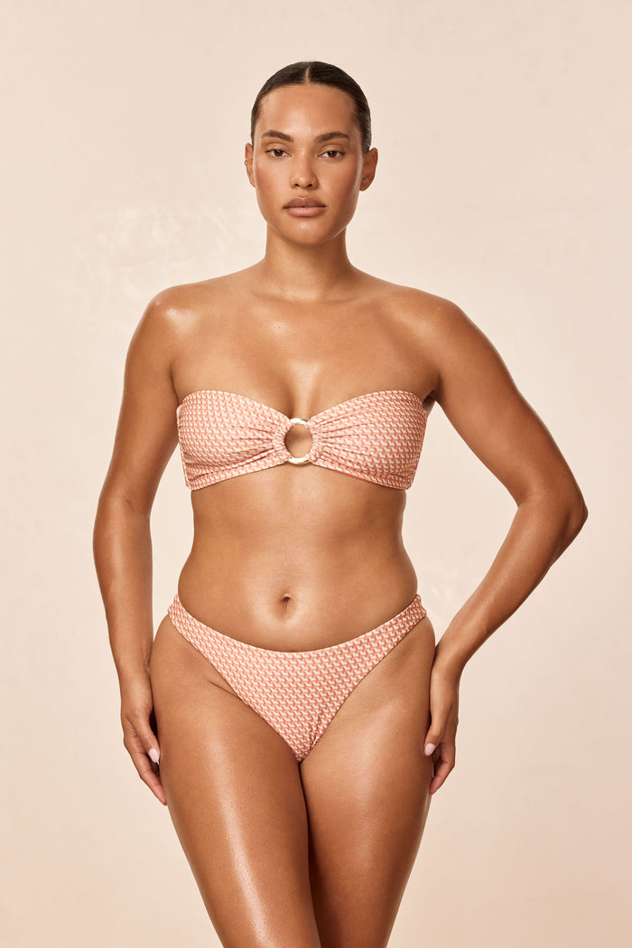 Front view of Tamarama bottom in Micro Geo print on model, mid-rise moderate coverage with neutral beige background