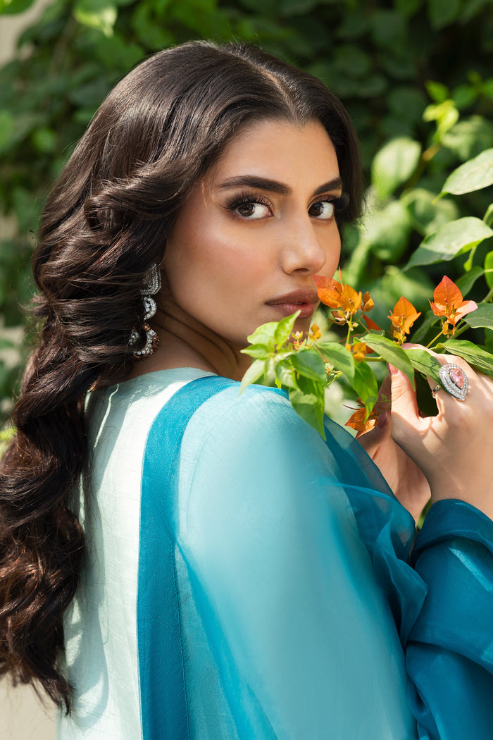 Detailed shot of NAQSHI Tania shirt sleeve showing intricate adda work—kora, dabka, cut dana, pastel stones and mirror embellishments on aqua fabric.