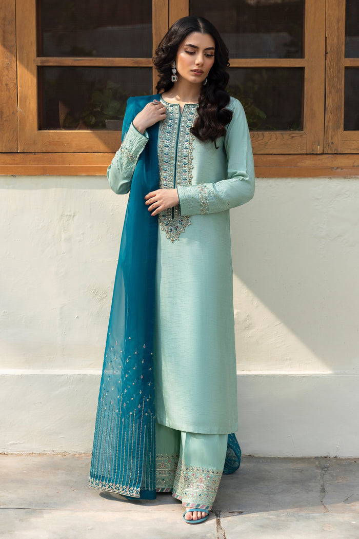 Model wearing full NAQSHI Tania 3PC: aqua‑teal raw‑silk shirt with detailed adda neckline, embroidered culottes and contrasting teal organza dupatta.