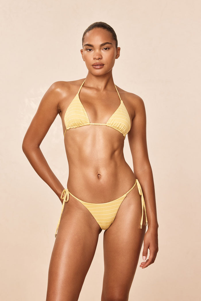 Front view of Taormina Bottom in Meyer Stripe showcasing adjustable side ties and gold hardware on beige background