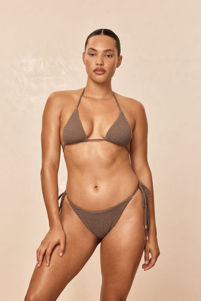 Front view of Taormina Bottom in Stone Crinkle showing low-rise fit and adjustable side ties on beige background