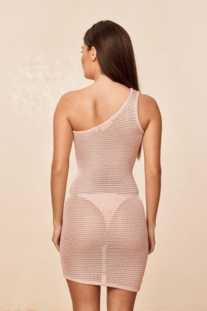 Back view of Taormina Dress in powder pink treble knit showing one-shoulder and open-knit texture on neutral background