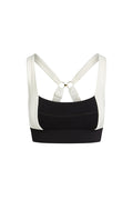 Black and white sports bra with wide band, padded cups, and crisscross back straps with gold rings.