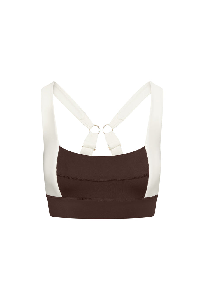 Front close-up of Tash Bra in Espresso/Ivory with wide ivory straps crossed at double gold rings on white background
