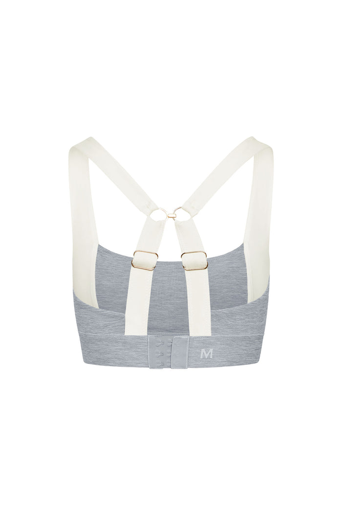 Back view of Tash Bra in Heather Grey/Ivory showing ivory cross-back straps with gold rings and hook-and-eye closure on white