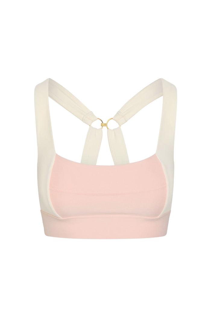 Front view of Tash Bra in heather powder pink and ivory showcasing crossed ivory straps joined by a gold ring and a wide underbust band on a white background