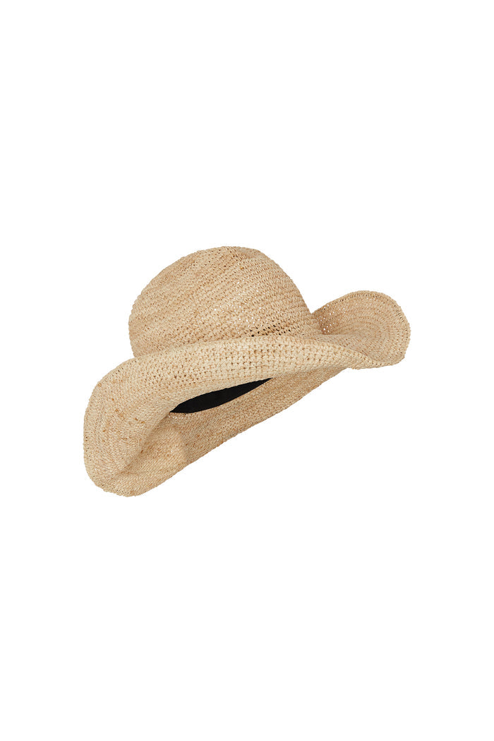 Angled view of straw wide-brim floppy sun hat showcasing woven raffia texture and black inner band on white background