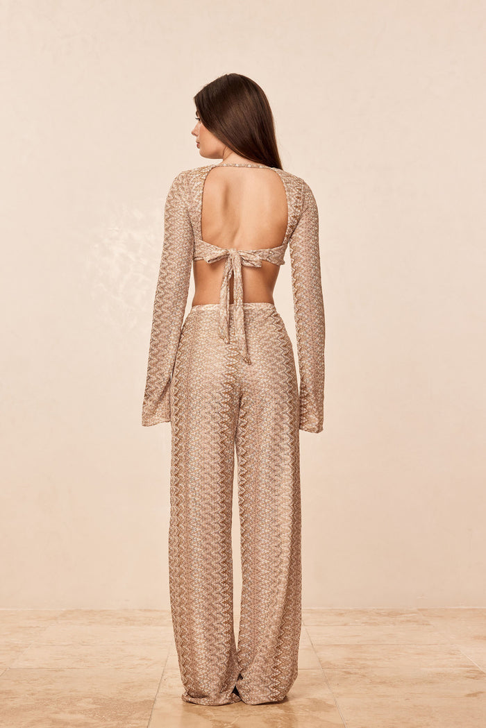Back view of Toulon Pant in Porto Cervo Gold showcasing textured crochet knit wide-leg fit on beige background