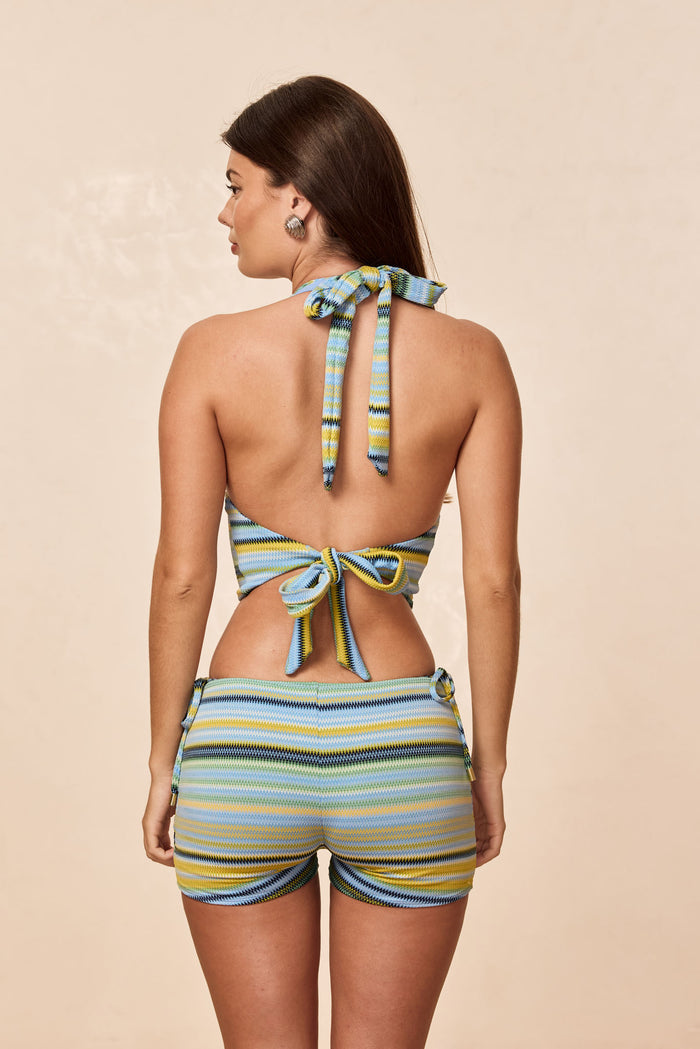 Rear view of Toulon Top in Sardinia Stripe Azure worn, open back with halter and tie-back, cropped fit