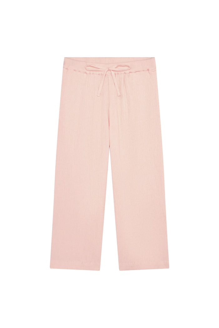 Flat lay of Tuscany Pant Kids powder pink crinkle showing smocked waistband, drawstring tie, and wide flare legs on white