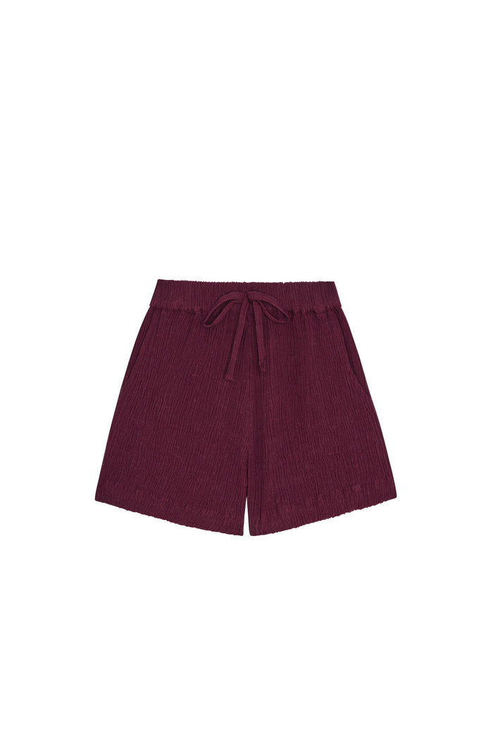 Front view of kids' Tuscany shorts in fig showing elastic waist with faux tie, crinkled fabric and side pockets on white