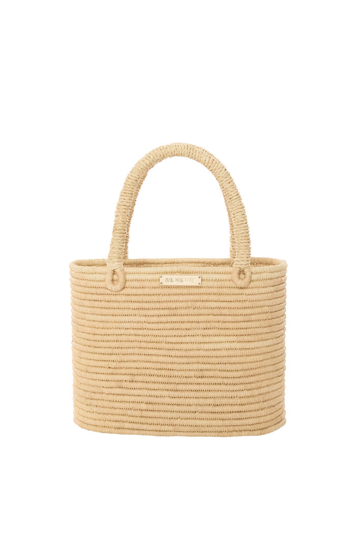 Front view of Valencia small woven raffia bag showing structured body, gold MONDAY logo plate, and rope handles on white background