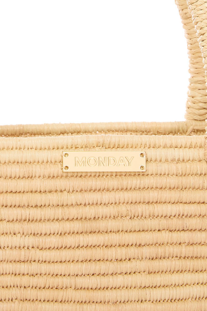 Close-up of Valencia Bag (Small) showcasing woven raffia texture and gold MONDAY logo plate on a white background