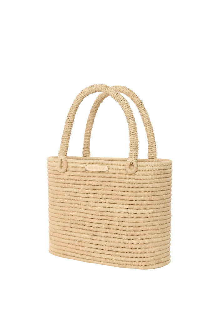 Close-up front view of Valencia Bag small showcasing woven raffia body, wrapped rope handles and gold MONDAY logo plate on white background