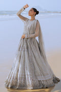 Side profile of NAQSHI Valeria showcasing the flow of silver net frock, layered sequin and floral embroidery on bodice extending to sleeves, and plain straight PK raw‑silk pants.