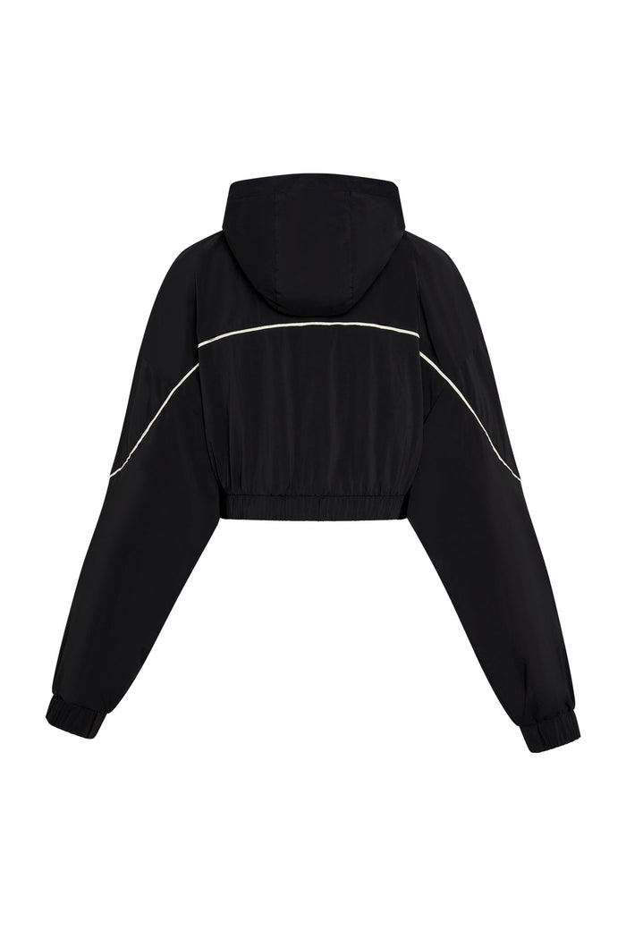 Cropped black hooded windbreaker jacket, back view, curved white piping across back and sleeves