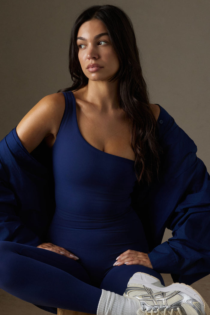 Front view of Windsor Tank in midnight on a seated model, one-shoulder neckline and fitted silhouette, neutral backdrop