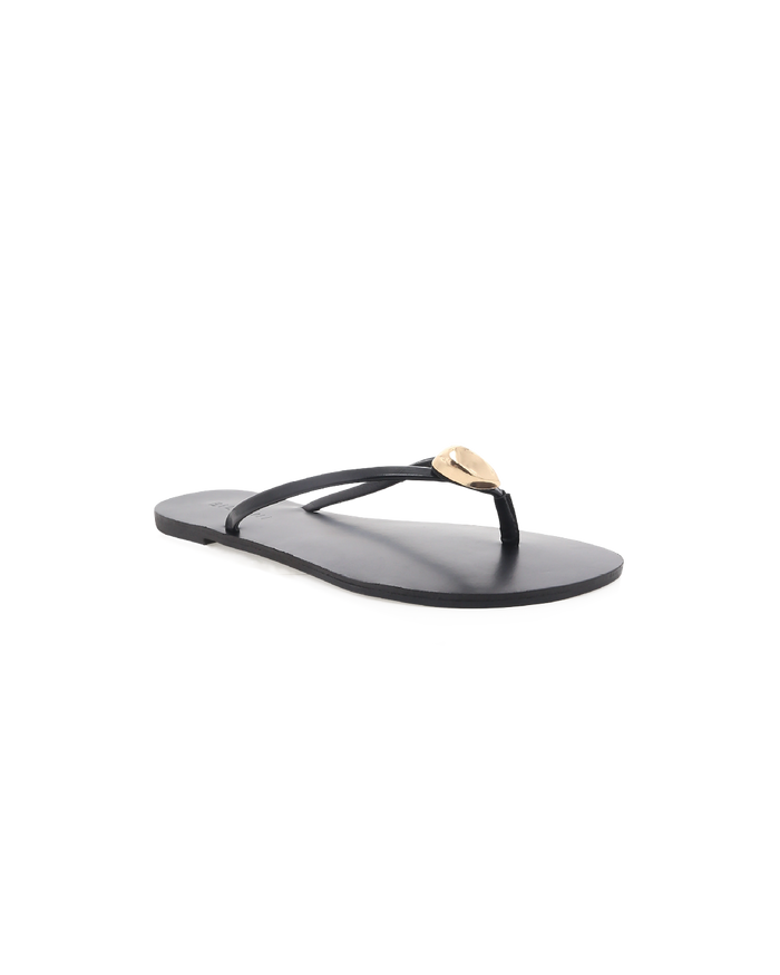 Black leather thong sandal with thin straps and gold teardrop ornament, flat sole, shown at slight angle.