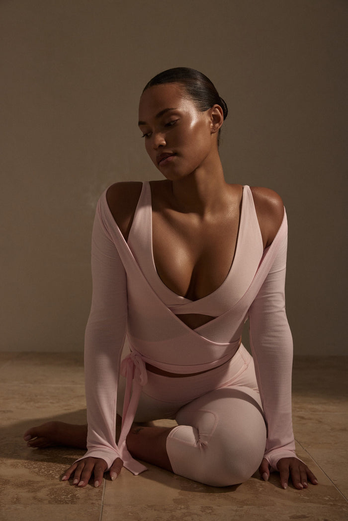 Front view of Yosemite Top in Powder Pink Lightweight Rib showing deep V neckline, wrap tie and long sleeves with thumb holes
