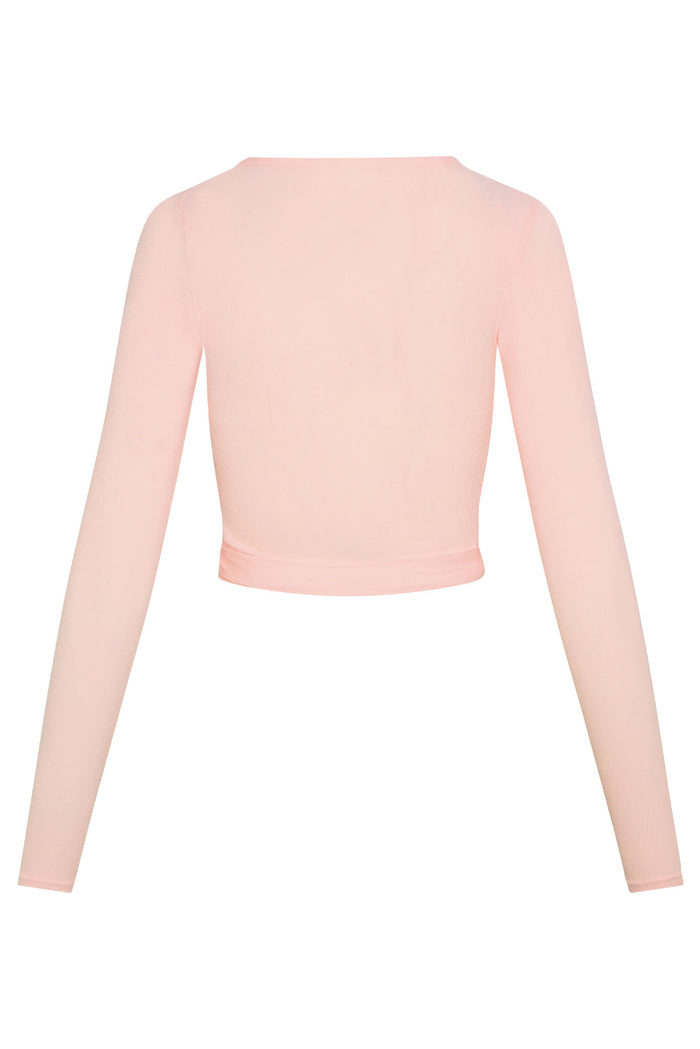 Back view of Yosemite Top in powder pink lightweight rib showcasing long sleeves and cropped wrap hem on white background