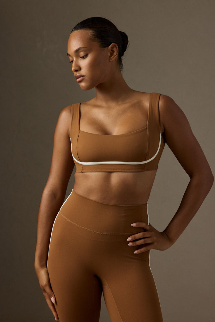 Three-quarter view of Zion Bra in Caramel/Ivory showing square neckline, contour seaming and contrast ivory trim